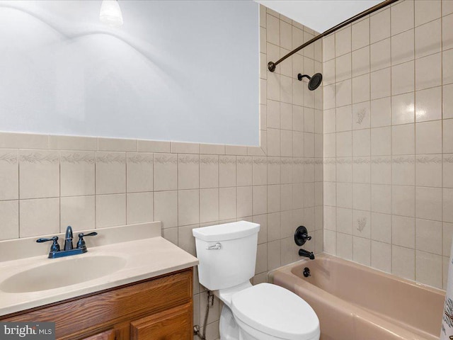 full bath with toilet, shower / washtub combination, tile walls, and vanity