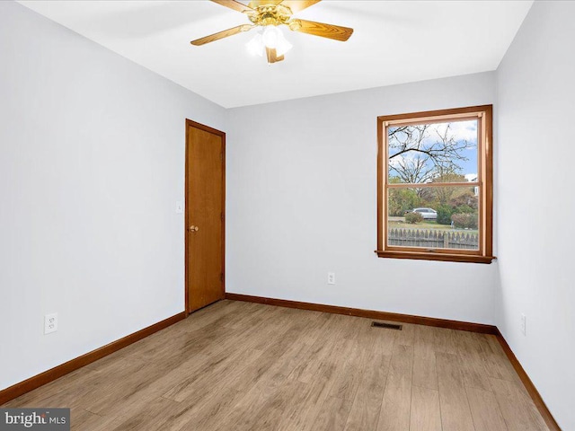 empty room with baseboards, ceiling fan, visible vents, and light wood-style floors