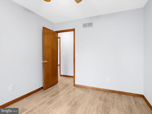 unfurnished room featuring baseboards, ceiling fan, visible vents, and light wood-style floors