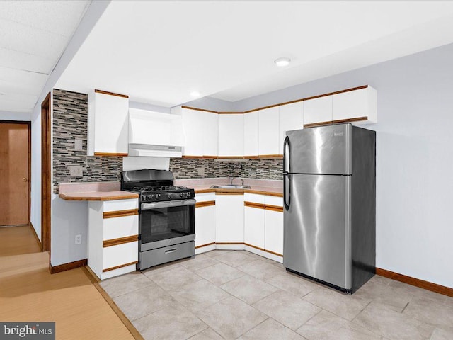 kitchen featuring a sink, stainless steel appliances, light countertops, and white cabinets