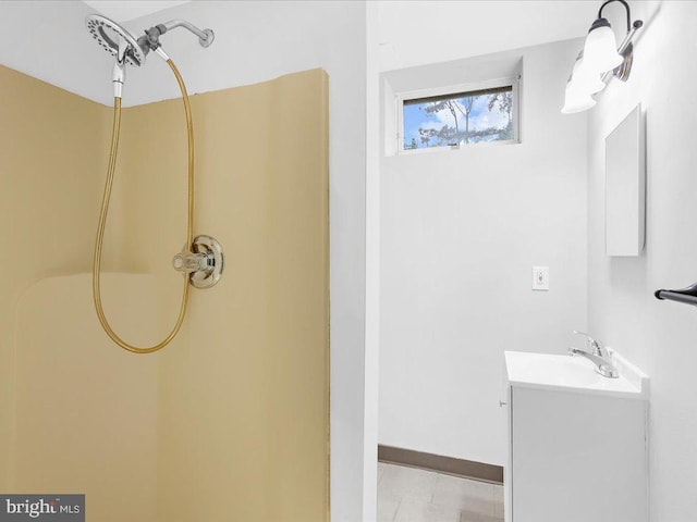 full bathroom with walk in shower, vanity, and baseboards