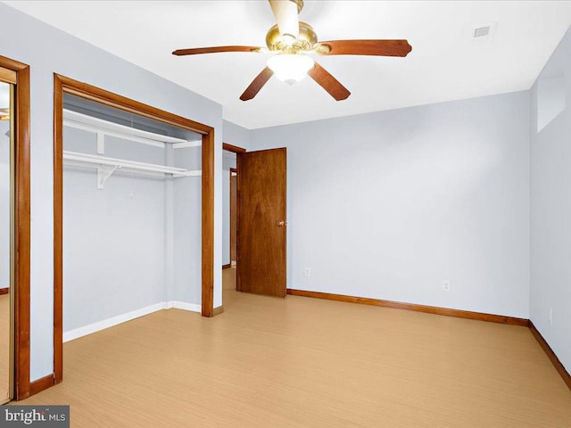 unfurnished bedroom featuring ceiling fan, light wood-style flooring, visible vents, baseboards, and a closet