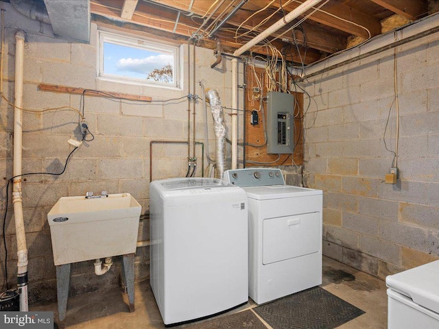 clothes washing area with laundry area, electric panel, independent washer and dryer, and a sink