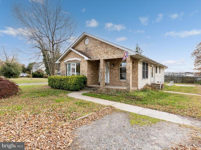 view of front of house featuring a front yard, fence, and brick siding