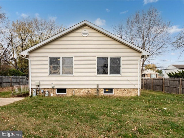 view of home's exterior with a lawn and fence