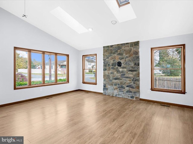 unfurnished living room with plenty of natural light, light wood-type flooring, and a skylight