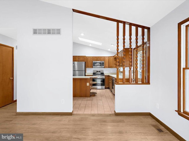 kitchen with stainless steel appliances, light countertops, brown cabinetry, and visible vents