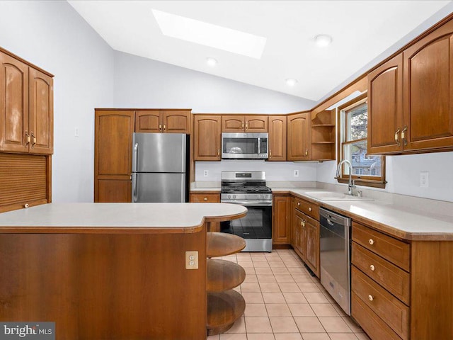 kitchen featuring open shelves, light countertops, appliances with stainless steel finishes, brown cabinetry, and a sink