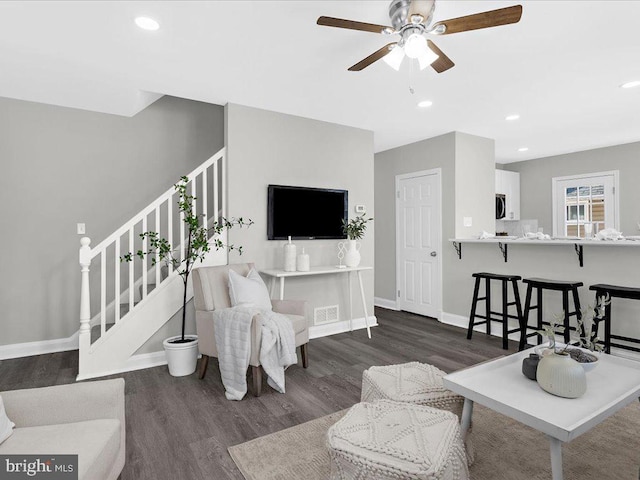 living room with dark wood-style floors, recessed lighting, visible vents, stairway, and baseboards