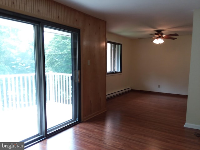 unfurnished room with a baseboard radiator, dark wood finished floors, a ceiling fan, and baseboards