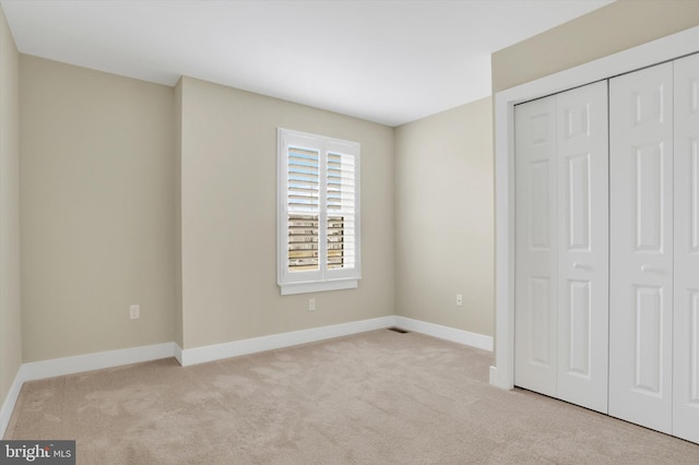 unfurnished bedroom featuring a closet, carpet flooring, and baseboards