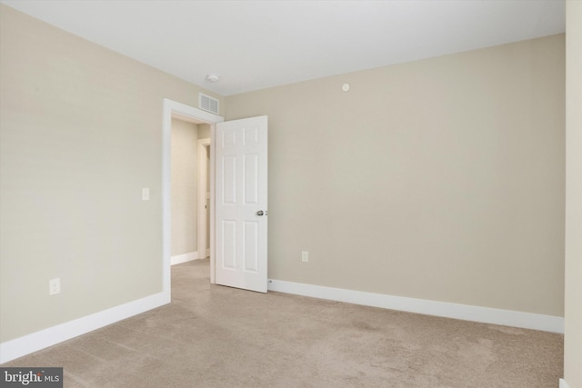 spare room with carpet floors, baseboards, and visible vents