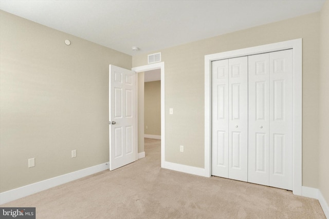 unfurnished bedroom featuring baseboards, a closet, visible vents, and carpet flooring