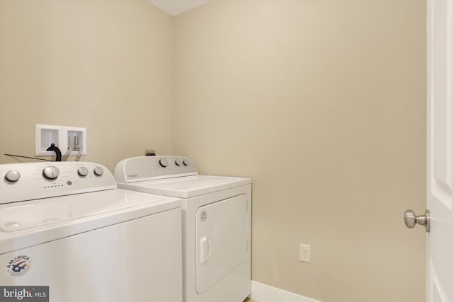 clothes washing area featuring laundry area, washer and clothes dryer, and baseboards