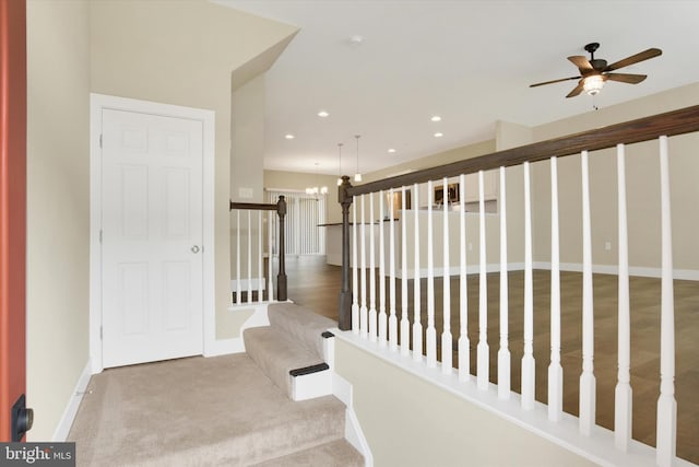 hall featuring carpet, a notable chandelier, recessed lighting, stairway, and baseboards