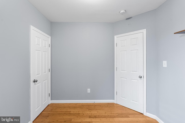 unfurnished bedroom with baseboards and wood finished floors