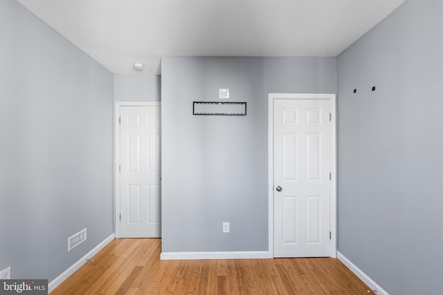 unfurnished bedroom featuring light wood-type flooring, baseboards, and visible vents