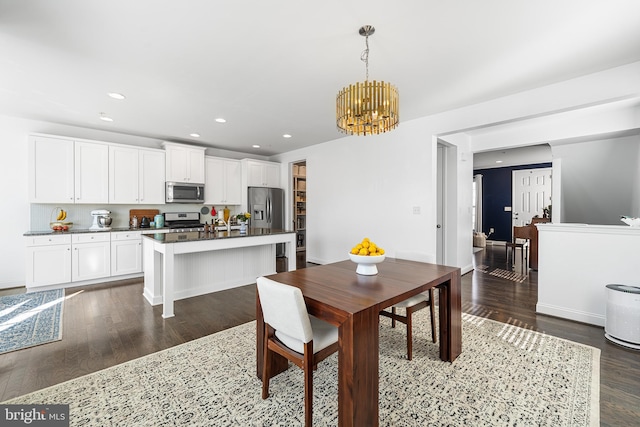 dining space featuring dark wood-style flooring, an inviting chandelier, and recessed lighting