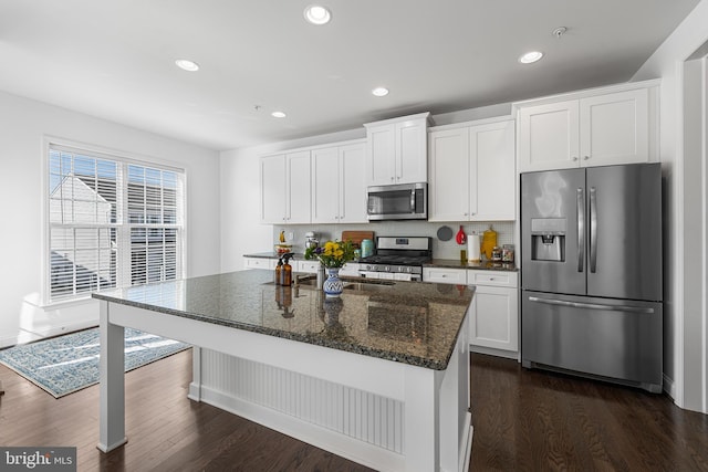 kitchen featuring stainless steel appliances, white cabinets, and dark wood finished floors