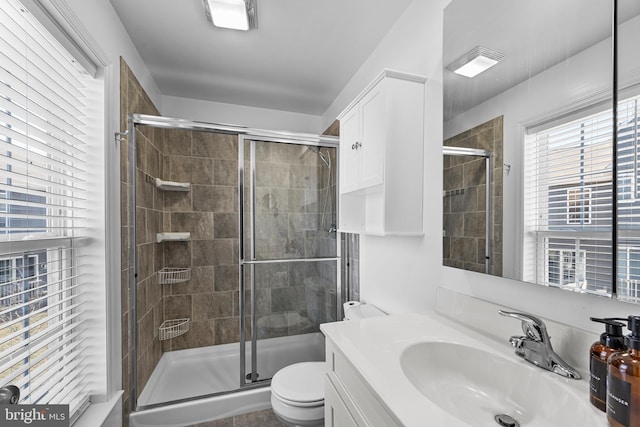 bathroom with visible vents, a shower stall, toilet, and vanity