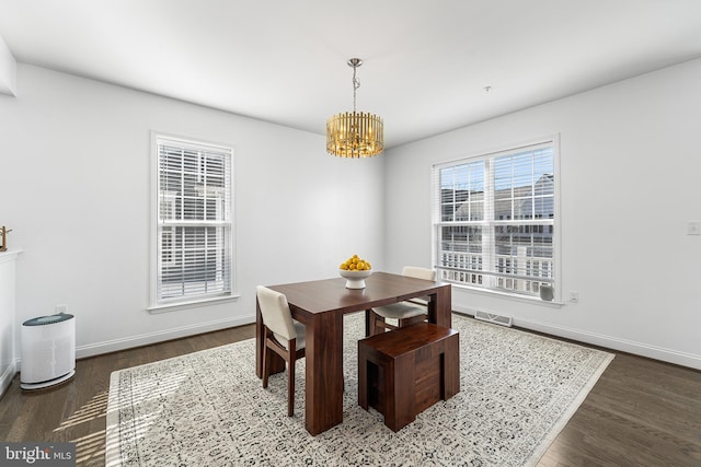 dining room featuring a chandelier, visible vents, baseboards, and wood finished floors