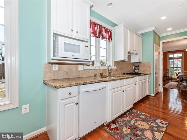 kitchen featuring stone countertops, white appliances, and white cabinetry