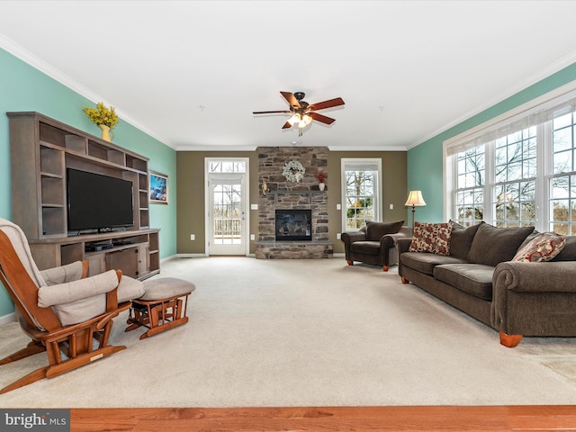 living area with ornamental molding, a fireplace, carpet flooring, and a wealth of natural light