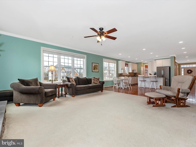 living area with carpet floors, ceiling fan, crown molding, and recessed lighting