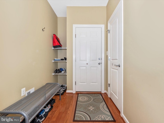 doorway featuring wood finished floors and baseboards