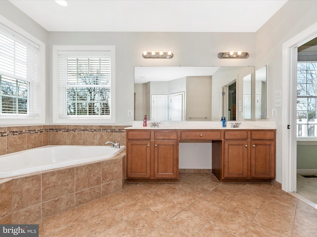 bathroom featuring tile patterned flooring, a healthy amount of sunlight, a garden tub, and double vanity