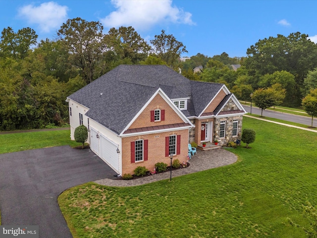 view of front of house featuring a shingled roof, brick siding, driveway, and a front lawn