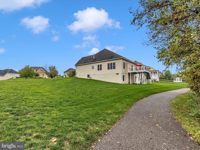 view of side of home with a wooden deck and a yard