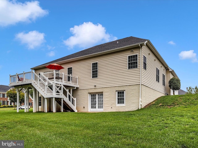 rear view of house with stairs, brick siding, a lawn, and a wooden deck