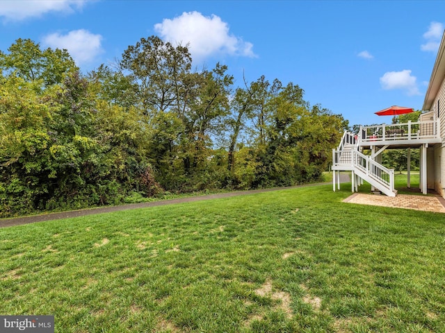 view of yard with a deck and stairs