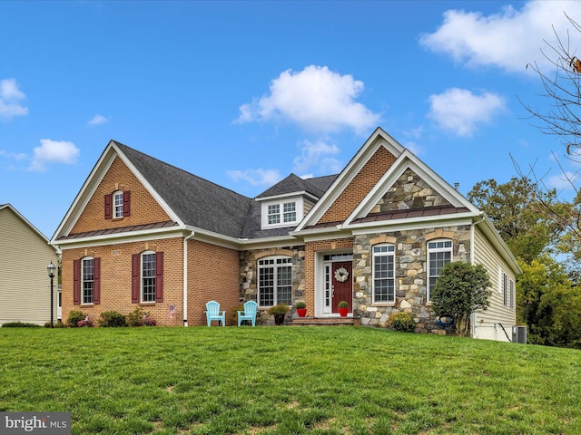 view of front facade featuring a front yard, stone siding, and brick siding