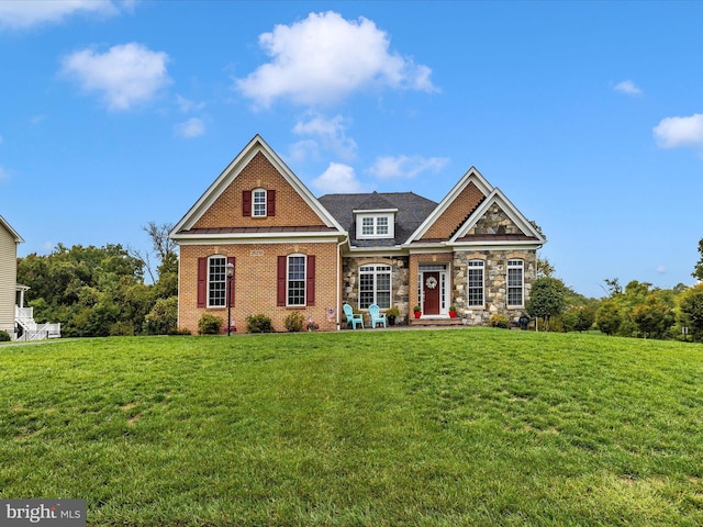 view of front of property featuring a front yard, stone siding, and brick siding