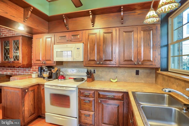 kitchen with white appliances, tasteful backsplash, light countertops, and a sink