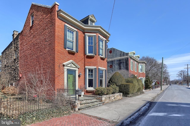 view of front of house with fence and brick siding