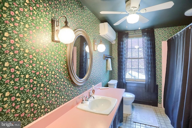 bathroom featuring ceiling fan, a wall unit AC, toilet, vanity, and wallpapered walls