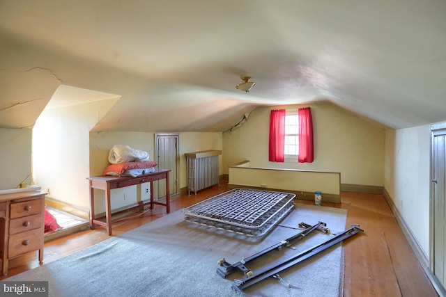 bonus room with baseboards, vaulted ceiling, and wood finished floors