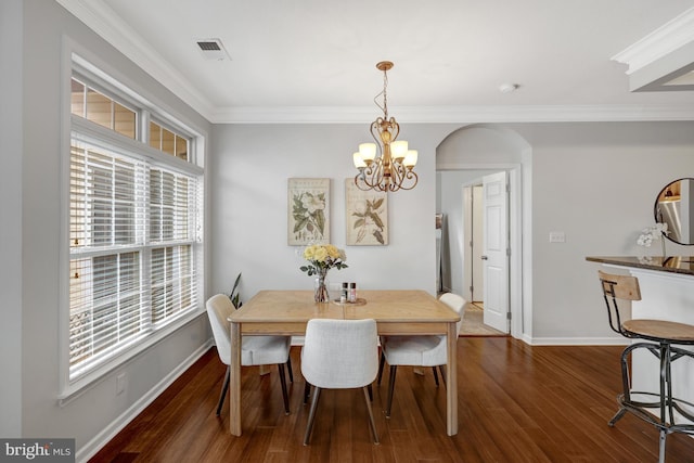 dining area with ornamental molding, dark wood finished floors, baseboards, and an inviting chandelier