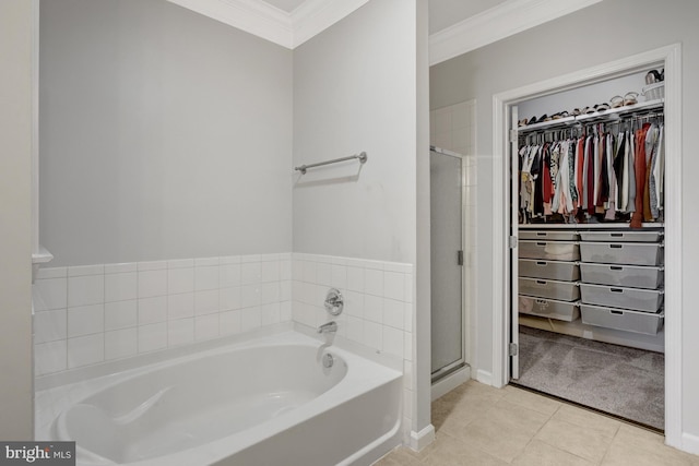 full bathroom featuring a spacious closet, ornamental molding, a stall shower, a bath, and tile patterned floors