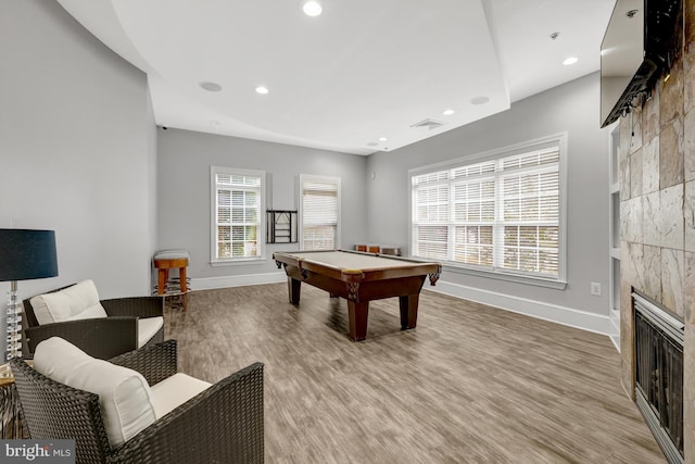 recreation room with visible vents, baseboards, a glass covered fireplace, light wood-style flooring, and recessed lighting