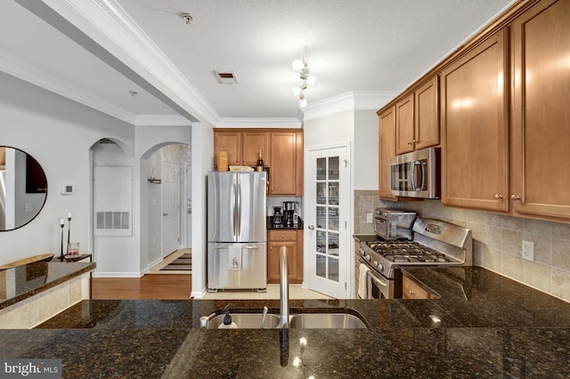 kitchen with appliances with stainless steel finishes, brown cabinets, and a sink