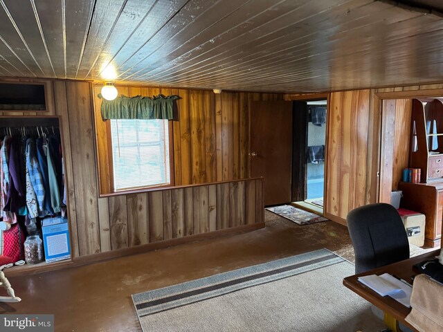 home office with concrete floors, wood walls, and wood ceiling