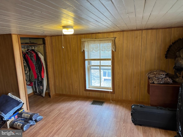 bedroom with wooden ceiling, visible vents, baseboards, light wood-style floors, and a closet