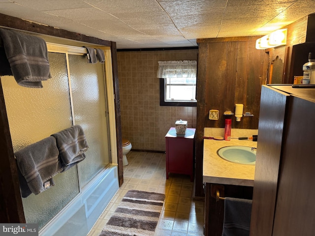 full bath featuring shower / bath combination with glass door, vanity, and toilet