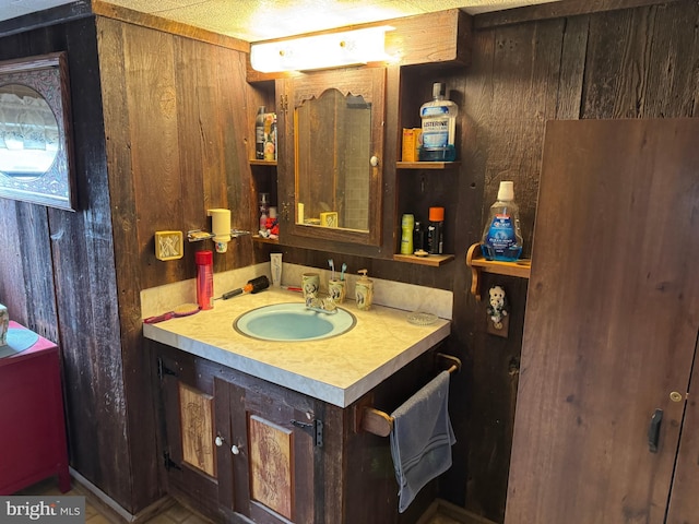 bathroom featuring wooden walls and vanity