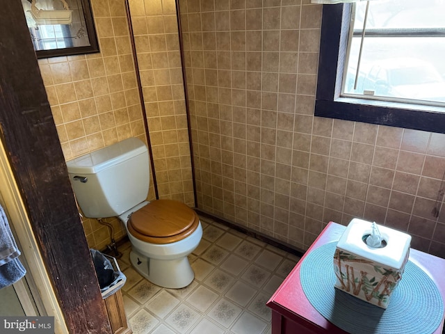 bathroom featuring toilet, vanity, and tile walls