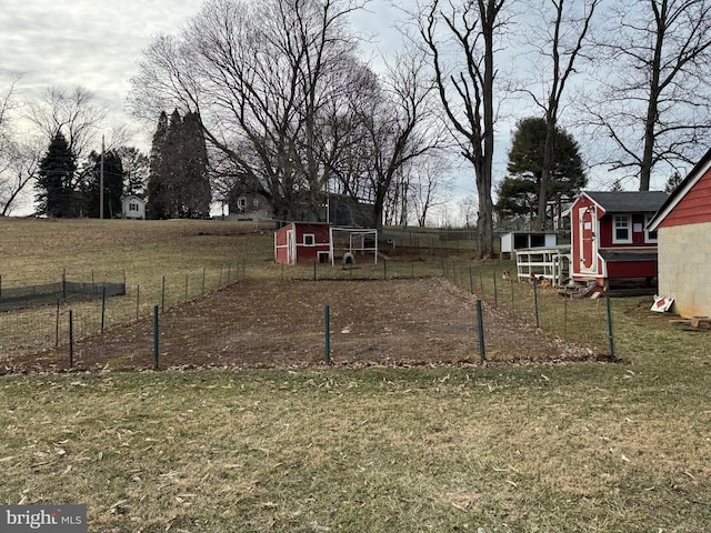 view of yard with an outdoor structure, fence, and exterior structure